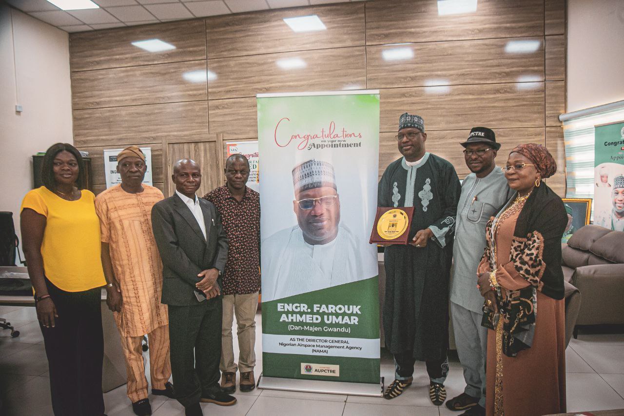 Group picture of NAMA MD Engr Farouk receiving an award from AUPCTRE head Benjamin Anthony during a visit.